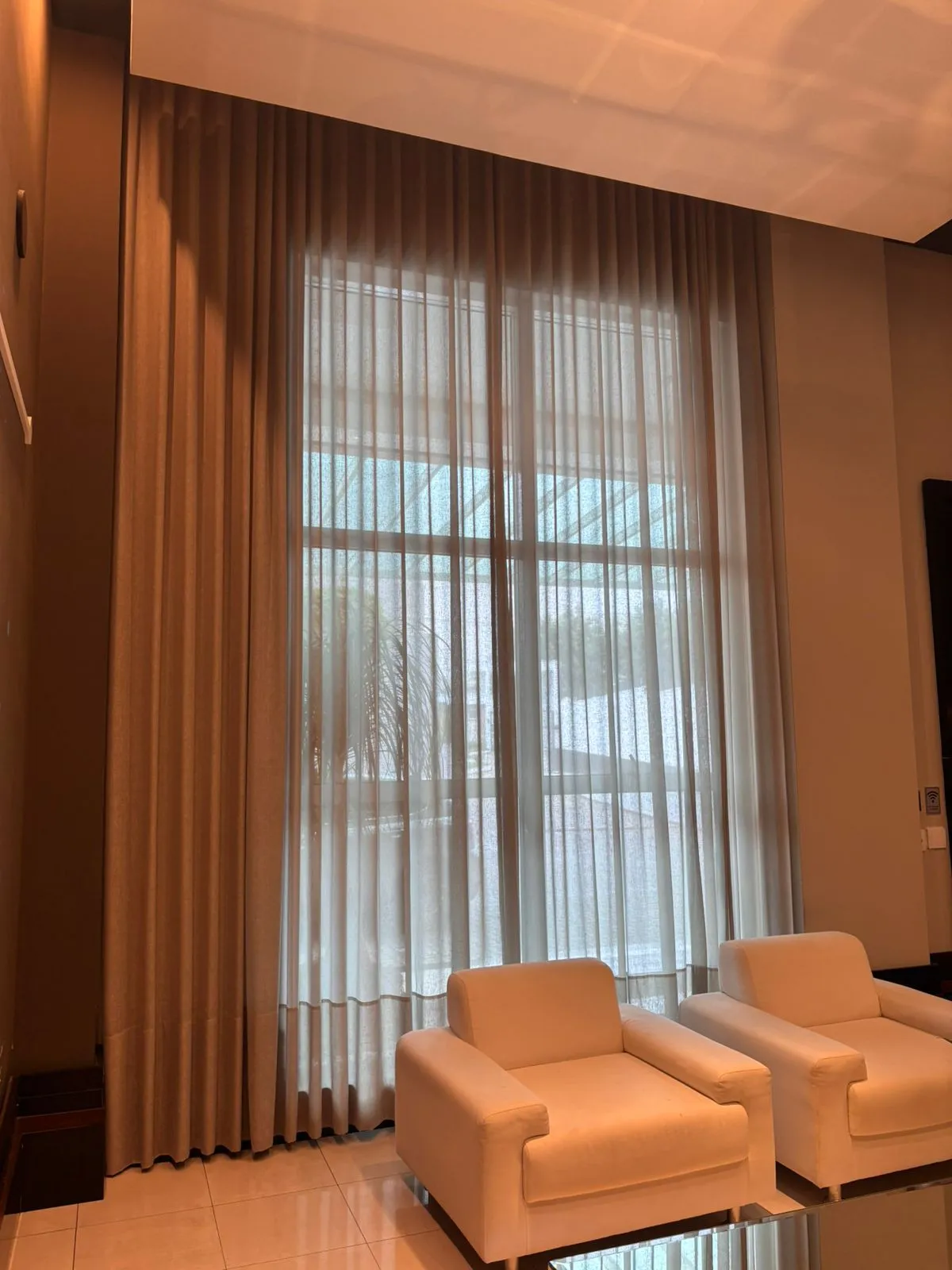 Sala com pé-direito duplo depois: cortina wave com voil sob medida